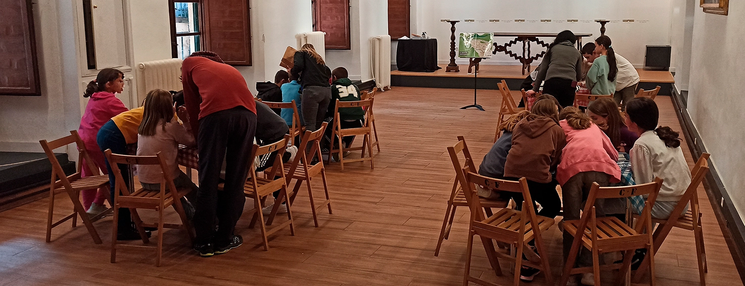 Niños en un taller educativo en el Palacio Episcopal de Segovia participando en actividades interactivas.