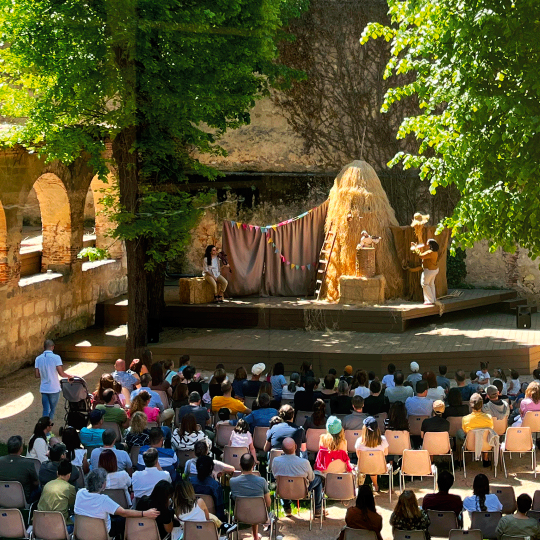 Representación teatral al aire libre en el jardín del Palacio Episcopal de Segovia, con público asistiendo.